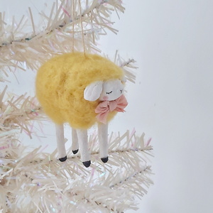 A yellow, vintage style needle felted spun cotton sheep ornament hanging on a white tree. Pic 3 of 7. 