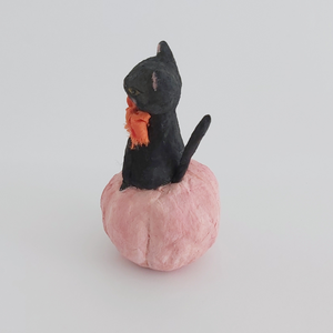 A side view of a vintage style spun cotton black cat sitting in a pink pumpkin, against a white background. Pic 6 of 7. 