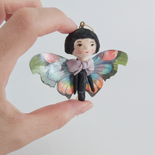 Cargar imagen en el visor de la galería, Close up of a vintage style spun cotton butterfly girl, held in hand. Pic 3 of 7. 
