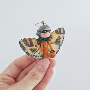 A vintage style, spun cotton Halloween butterfly girl held in a hand against a white background. Pic 2 of 7. 