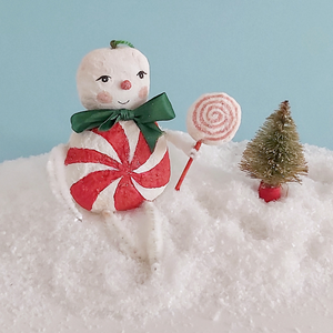 A vintage style spun cotton candy man Christmas ornament sitting on fake snow next to a mini bottle brush tree. Pic 3 of 8. 
