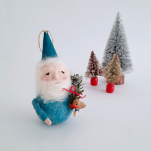 Load image into Gallery viewer, Decorative gnome with a blue hat and outfit, holding a small robin, with miniature trees in the background on a white background.
