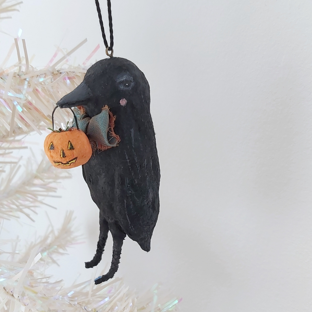A vintage style spun cotton crow ornament hanging on a tree against a white background. Pic 1 of 8. 