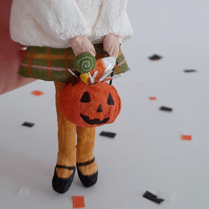 A closeup of a vintage style, spun cotton jack-o-lantern bucket with treats. Pic 3 of 7. 