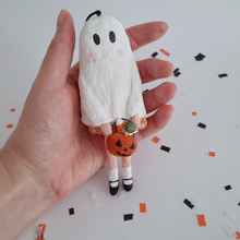 Cargar imagen en el visor de la galería, A hand holding a vintage style, spun cotton ghost girl ornament over Halloween confetti on a white background. Pic 2 of 8. 
