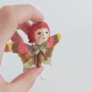 A closer view of spun cotton ginger butterfly girl, held in hand against a white background. Pic 2 of 7. 