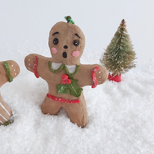 Load image into Gallery viewer, A close-up of a vintage style, spun cotton gingerbread girl ornament. A mini bottle brush tree sits behind her, on fake snow. Pic 5 of 8.  
