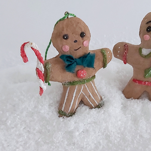 A close-up of a vintage style spun cotton gingerbread man ornament, against a white background. Pic 3 of 8. 