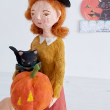 Load image into Gallery viewer, Another close-up of a vintage style, spun cotton Halloween girl art doll. A Halloween greeting hangs in the background. Pic 4 of 7.
