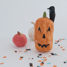 Load image into Gallery viewer, A vintage style spun cotton jack-o-lantern and crow ornament, sitting in front of other spun cotton pumpkins on Halloween confetti against a white background. Pic 1 of 8. 

