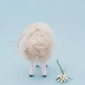 Back view of a vintage style, spun cotton needle felted sheep against a light blue background. Pic 6 of 7. 