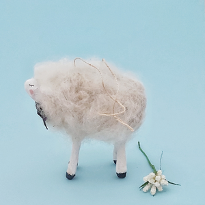 An opposite side view of a vintage style spun cotton needle felted sheep ornament against a light blue background. Pic 6 of 6. 