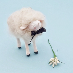 A white, vintage style spun cotton needle felted sheep ornament standing against a light blue background. Pic 3 of 6. 