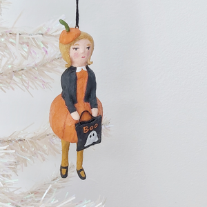 Vintage style spun cotton pumpkin girl ornament, hanging on tree. Pic 2 of 9.