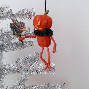 A vintage style, spun cotton pumpkin man ornament hanging on a silver tree. Pic 3 of 8. 