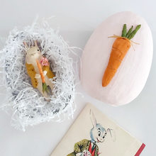 Cargar imagen en el visor de la galería, A vintage style, spun cotton bunny ornament laying in a light pink paper mache egg box with white tissue shredding. A vintage Easter card lays below in the photo. Pic 11 of 12. 
