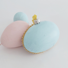 Cargar imagen en el visor de la galería, A back view of a vintage style, spun cotton sheep diorama egg ornament. It&#39;s laying against a pink and blue egg ornaments. Pic 6 of 6. 
