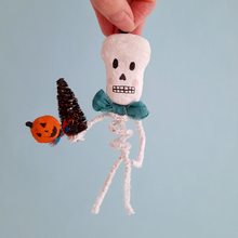 Load image into Gallery viewer, A vintage style, spun cotton pipe cleaner skeleton ornament held against a light blue background. Pic 3 of 4.
