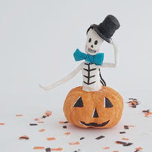 Load image into Gallery viewer, A vintage style, spun cotton skeleton in a jack-o-lantern sitting on Halloween confetti. Pic 1 of 7. 

