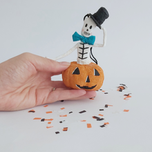 Load image into Gallery viewer, A hand holding a vintage style, spun cotton skeleton in a jack-o-lantern. Pic 2 of 7. 
