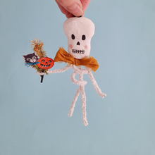 Load image into Gallery viewer, A vintage style, spun cotton pipe cleaner skeleton held against a light blue background. Pic 3 of 4. 
