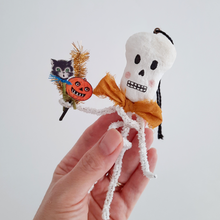 Load image into Gallery viewer, A vintage style, spun cotton pipe cleaner skeleton ornament, held in hand against a white background. Pic 1 of 4.
