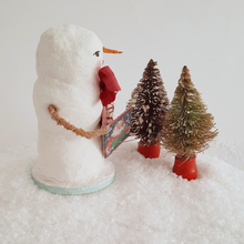 Load image into Gallery viewer, An opposite side view of a vintage style, spun cotton snowman standing behind two vintage bottlebrush trees. Pic 5 of 6.
