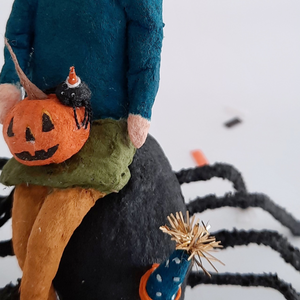 A close-up of the vintage style, spun cotton jack-o-lantern and spider sitting on a spun cotton girl's lap. Pic 6 of 10. 