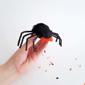 A hand holding a vintage style, spun cotton spider ornament over a white background. Pic 2 of 8. 