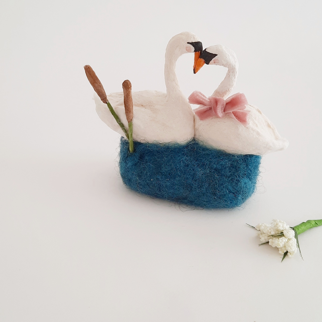 A vintage style spun cotton swan sculpture against a white background. A small white flower bunch sits in front. Pic 1 of 5. 