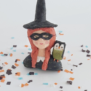 A closer view of a vintage style spun cotton witch girl ornament, sitting on Halloween confetti on a white background. Pic 3 of 9. 