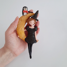 Cargar imagen en el visor de la galería, A hand holding a vintage style, spun cotton witch on moon ornament. Pic 2 of 8. 
