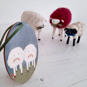 An image of a wooden sheep ornament with three spun cotton sheep in the distance. Pic 4 of 6.