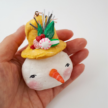 Cargar imagen en el visor de la galería, Spun cotton snowman with mustard yellow top hat, held in hand. Photo 2
