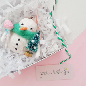 Spun cotton snowman ornament, laying in white gift box with white tissue shredding. Photo 3