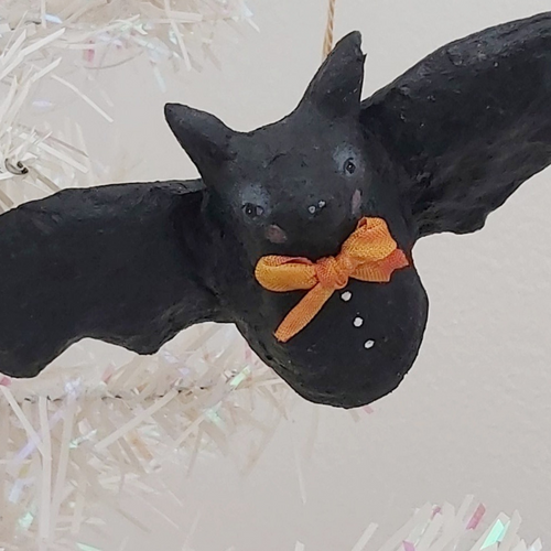 Close up view of spun cotton bat ornament, hanging from tree. Pic 1 of 8.