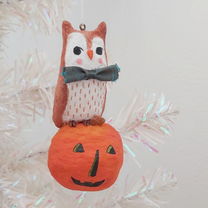 Spun cotton owl on jack-o'-lantern ornament, hanging from tree. Pic 1 of 8.