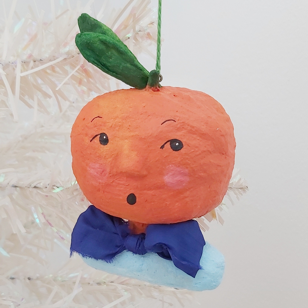 Spun cotton orange boy ornament hanging from tree. Pic 1 of 6.