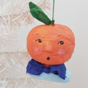 Closer photo of spun cotton orange boy ornament, hanging from tree. Pic 5 of 6.