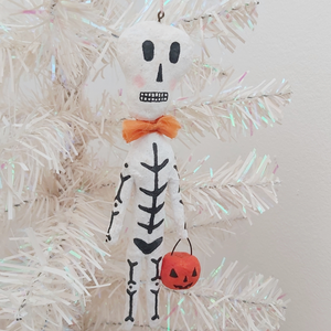 Spun cotton skeleton ornament, hanging in tree. Pic 2 of 5.