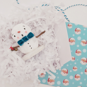Spun cotton snowman laying in white gift box with white tissue shredding. Pic 4 of 6. 