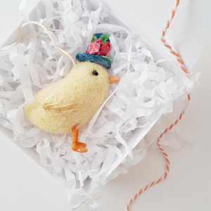 Needle felted chick laying in white gift box with shredded white tissue paper, orange and white bakers twine to the side (picture 5)