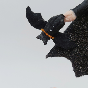 Close up of tiny spun cotton bat being held in bat girl's hand. Pic 4 of 9.