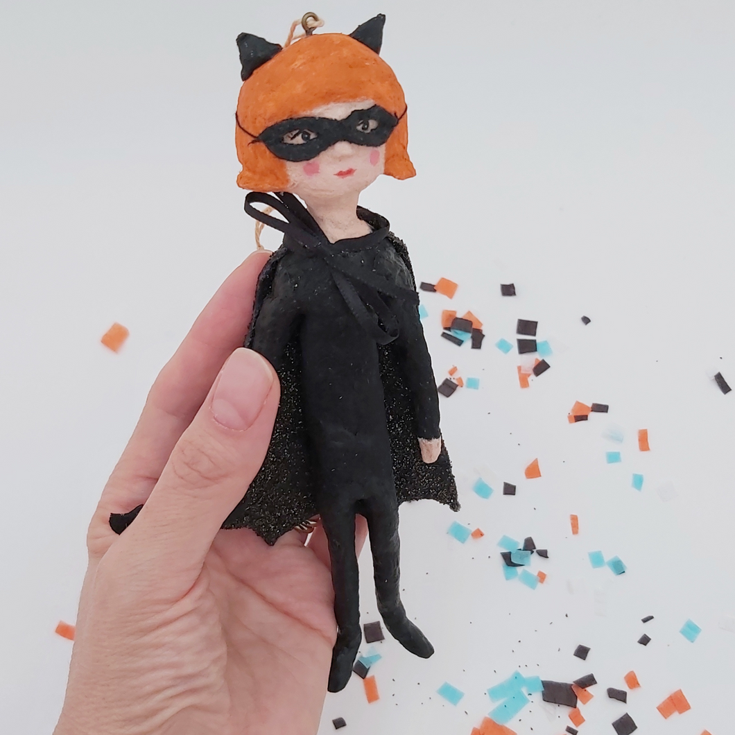 Spun cotton bat girl ornament, held in hand on white background with Halloween confetti below. Pic 1 of 9.