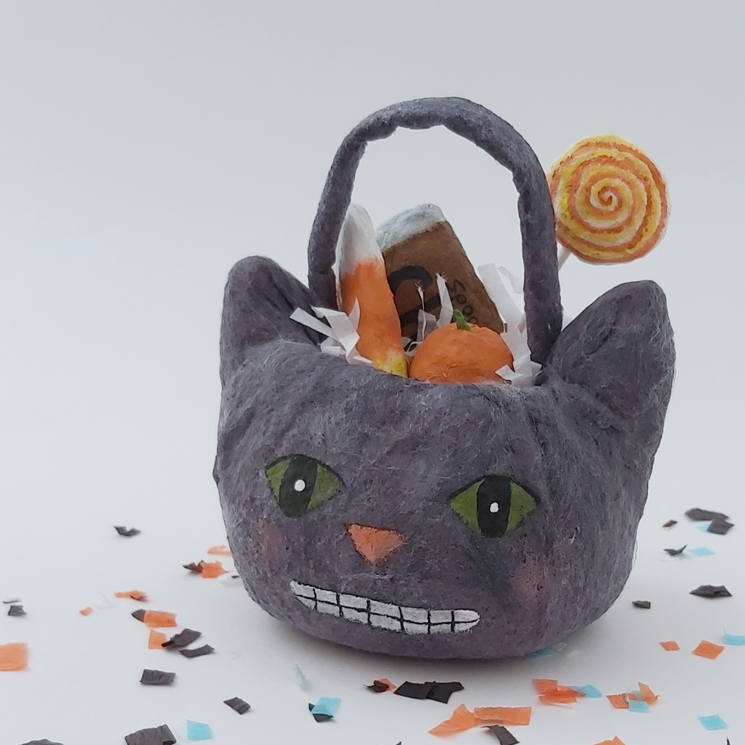 Spun cotton cat Halloween bucket filled with spun cotton candy, sitting on a white background with Halloween confetti. Pic 1 of 5.