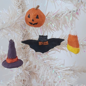 Spun cotton witch hat, jack-o-lantern, bat and candy corn ornaments hanging on tree. Pic 3 of 6.