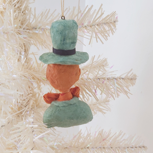 Back view of spun cotton leprechaun ornament, hanging from white tree. Pic 7 of 7.