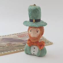 Cargar imagen en el visor de la galería, Spun cotton leprechaun ornament, sitting next to vintage Ireland souvenir booklet. Pic 6 of 7.
