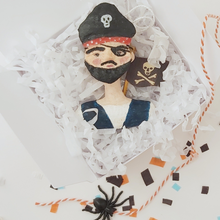 Cargar imagen en el visor de la galería, Spun cotton pirate boy ornament, laying in white gift box with white tissue shredding and orange bakers twine. Pic 4 of 7. 
