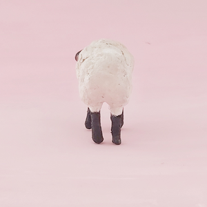 A back view of a vintage style spun cotton miniature sheep, against a pink background. Pic 7 of 8. 